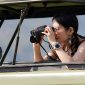 A tourist using binoculars to view wildlife Tanzania jpg